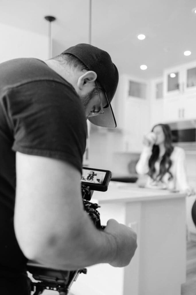 Looking over the shoulder of a man filming a woman drinking coffee